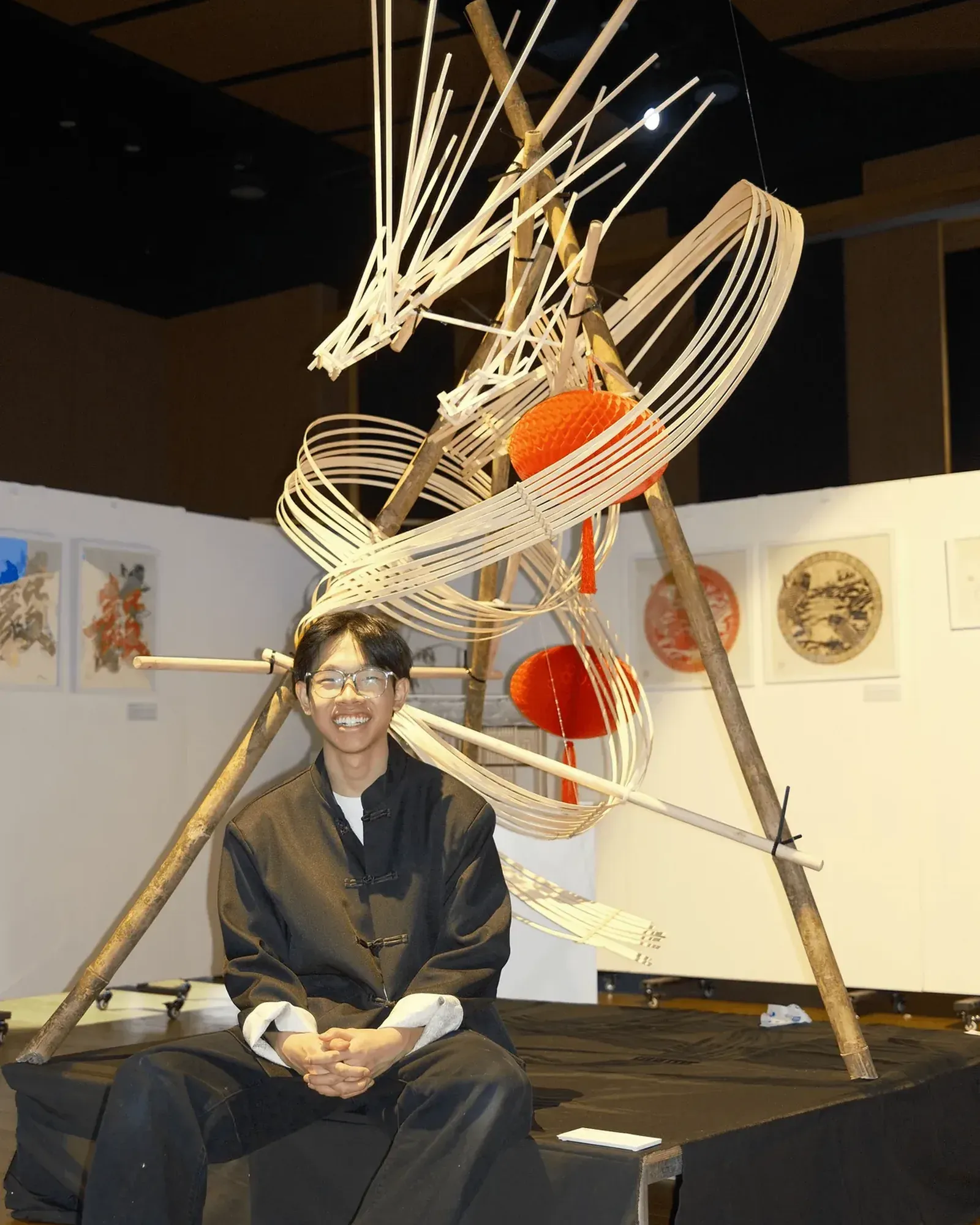 Royden sitting on the plinth beneath the bamboo dragon